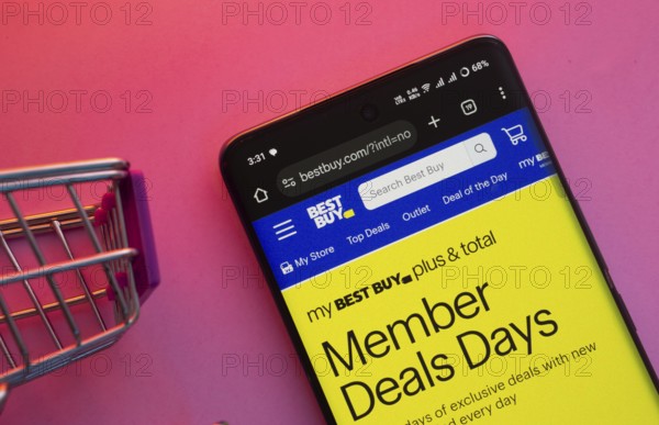 Dhaka, Bangladesh- 23 June 2025: A smartphone displaying the Best Buy website with a shopping cart is shown on a vibrant background