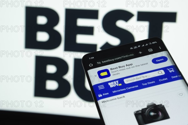 Dhaka, Bangladesh- 03 July 2025: Smartphone displaying Best Buy web interface against Best Buy logo background