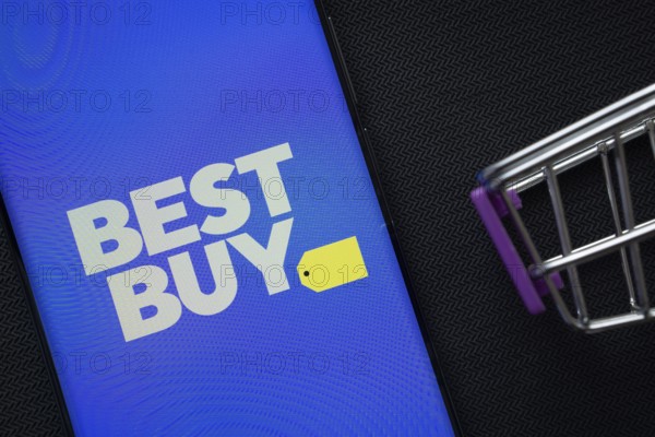 Dhaka, Bangladesh- 03 July 2025: A smartphone displaying the Best Buy logo next to a miniature shopping cart on a background