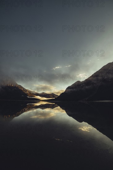 Sunrise with reflections in the Plansee in Tyrol in the Alps in Austria