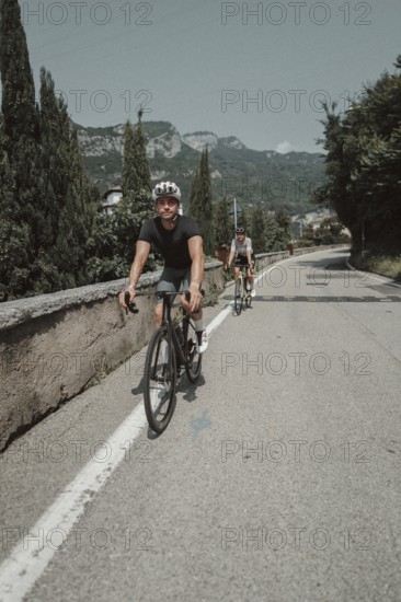 Woman and man cycling on Lake Garda in Italy. Sunny weather and dolce vita