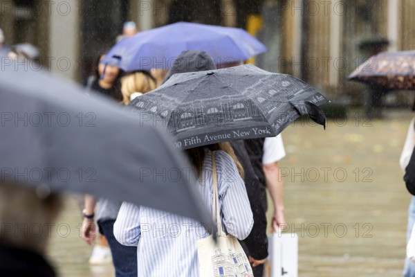 Rainy weather in Stuttgart. People with umbrellas hurry through the rain on Königstraße. Stuttgart, Baden-Württemberg, Germany