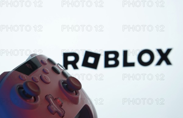 Dhaka, Bangladesh- 26 July 2025: A close-up of a gamepad with the Roblox seen on screen in the background