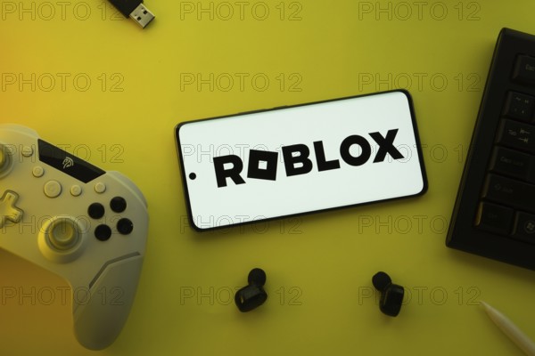 Dhaka, Bangladesh- 26 July 2025: A close-up of a gamepad with the Roblox seen on smartphone