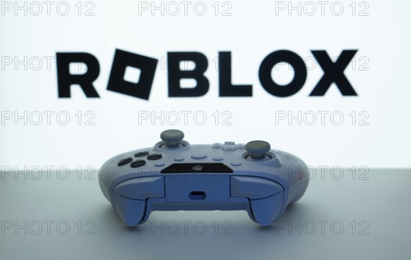 Dhaka, Bangladesh- 26 July 2025: Game controller in front of Roblox logo on a background