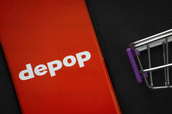Dhaka, Bangladesh- 03 July 2025: A smartphone displaying the Depop logo next to a miniature shopping cart on a background