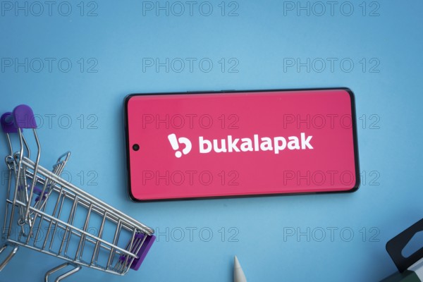 Dhaka, Bangladesh- 03 July 2025: Smartphone displaying Bukalapak logo with shopping cart on a blue background