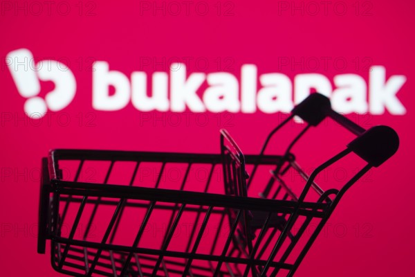 Dhaka, Bangladesh- 03 July 2025: Silhouette of a shopping cart in front of the Bukalapak logo, symbolizing ecommerce and online shopping