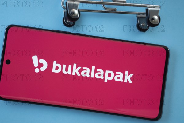 Dhaka, Bangladesh- 03 July 2025: Smartphone screen showing the Bukalapak logo with shopping cart wheels on a blue background