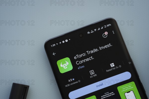 Dhaka, Bangladesh- 29 May 2025: On a blue surface, a smartphone displays the eToro app within the Google Play Store