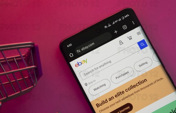 Dhaka, Bangladesh- 23 June 2025: A smartphone displaying the eBay website with a shopping cart is shown on a vibrant background