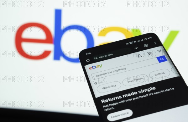 Dhaka, Bangladesh- 03 July 2025: Smartphone displaying eBay web interface against eBay logo background