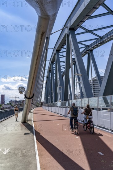 Cycle and pedestrian bridge Snelbinder Brug, over the river Waal near Nijmegen, was added to the existing railway bridge, fast cycle path connection from the city centre of Nijmegen and the new housing estates in the Waalsprong district, Netherlands