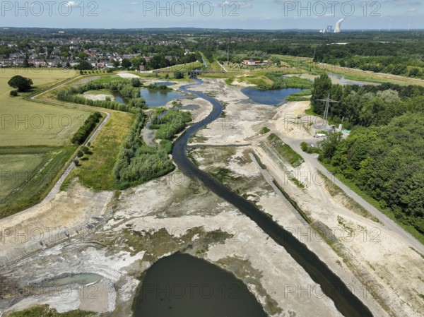 Dortmund, Castrop-Rauxel, North Rhine-Westphalia, Germany - River renaturalisation, renaturation of the Emscher, flood retention basin HRB Mengede. A new floodplain landscape is being created at the Emscher-Auen farm, expanding the area for flood protection during heavy rainfall and for biodiversity. The previously straightened Emscher is being given curves again and can meander through its new floodplain. Following the construction of a parallel sewer, the Emscher has been completely free of sewage since 2022. The river was previously an open, above-ground mixed water channel with rainwater and wastewater. At the back right, the Uniper coal-fired power plant Datteln 4 power station