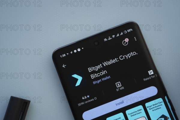 Dhaka, Bangladesh- 29 May 2025: On a blue surface, a smartphone displays the Bitget Wallet app within the Google Play Store