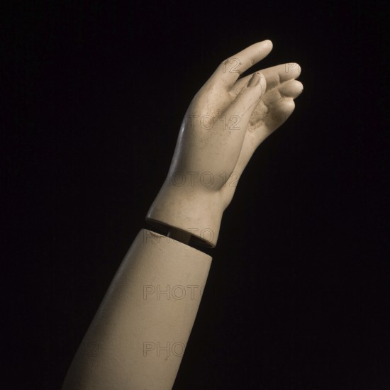 A detailed view of a mannequin hand with fingers slightly curled, creating a graceful pose against a dark background, showcasing the artistry in design and craftsmanship