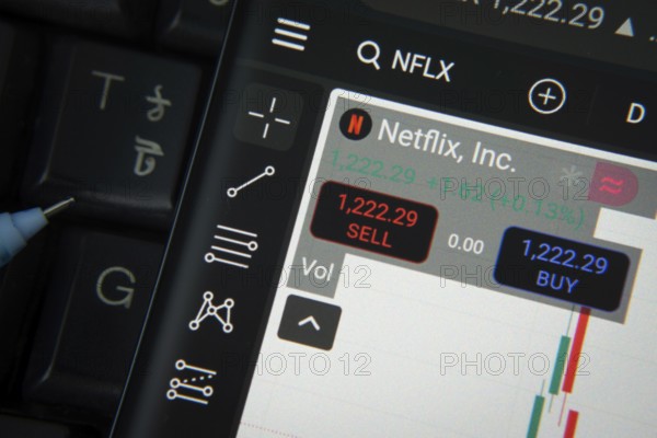 Dhaka, Bangladesh- 20 June 2025: Netflix Inc stock trading details on smartphone over a keyboard