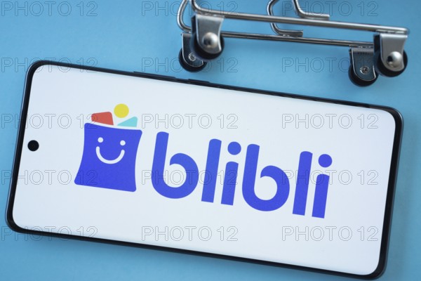 Dhaka, Bangladesh- 03 July 2025: Smartphone screen showing the Blibli logo with shopping cart wheels on a blue background