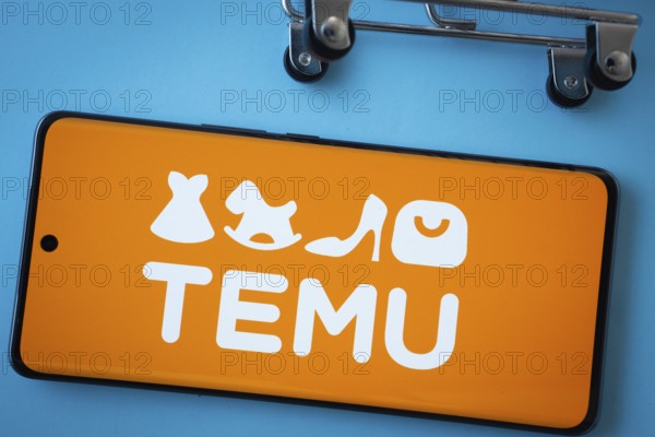 Dhaka, Bangladesh- 03 July 2025: Smartphone screen showing the Temu logo with shopping cart wheels on a blue background