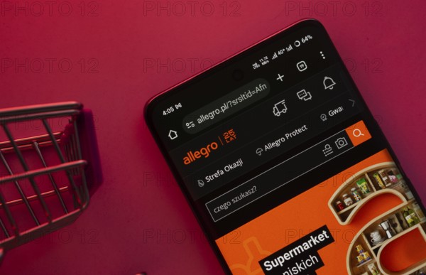 Dhaka, Bangladesh- 23 June 2025: A smartphone displaying the Allegro website with a shopping cart is shown on a vibrant background