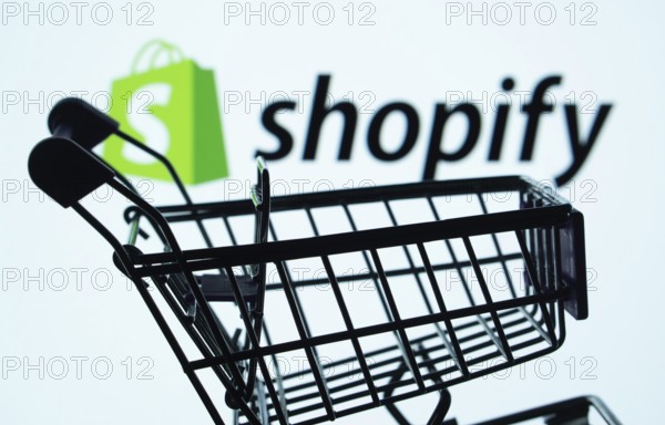Dhaka, Bangladesh- 03 July 2025: Silhouette of a shopping cart in front of the Shopify logo, symbolizing ecommerce and online shopping