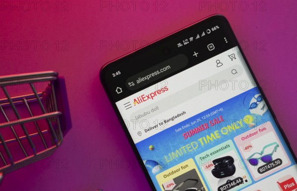 Dhaka, Bangladesh- 23 June 2025: A smartphone displaying the AliExpress website with a shopping cart is shown on a vibrant background