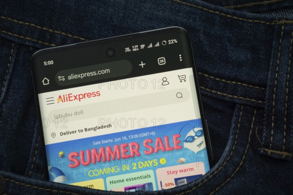 Dhaka, Bangladesh- 15 June 2025: A smartphone displaying the AliExpress web interface peeks out of a denim pocket
