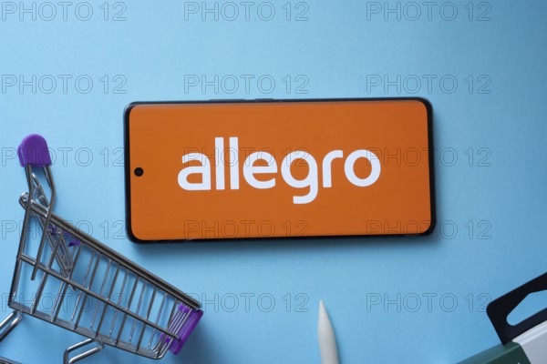 Dhaka, Bangladesh- 03 July 2025: Smartphone displaying Allegro logo with shopping cart on a blue background