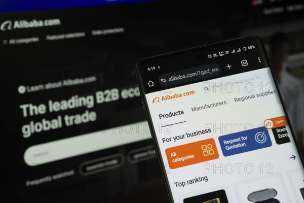 Dhaka, Bangladesh- 03 July 2025: Smartphone displaying Alibaba web interface against Alibaba website in the background