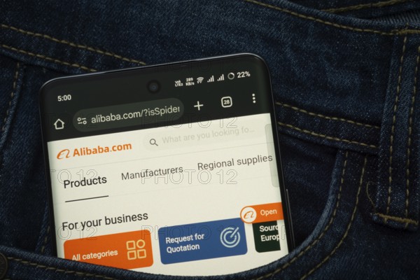 Dhaka, Bangladesh- 15 June 2025: A smartphone displaying the Alibaba web interface peeks out of a denim pocket