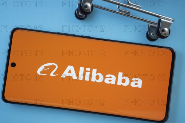 Dhaka, Bangladesh- 03 July 2025: Smartphone screen showing the Alibaba logo with shopping cart wheels on a blue background