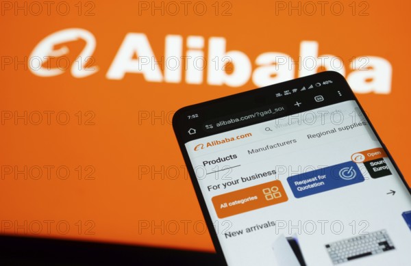 Dhaka, Bangladesh- 03 July 2025: Smartphone displaying Alibaba web interface against Alibaba logo background