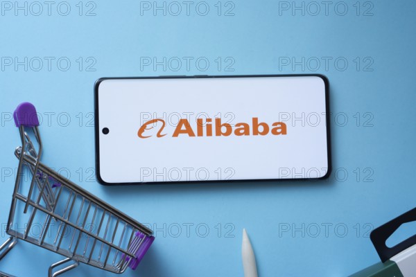Dhaka, Bangladesh- 03 July 2025: Smartphone displaying Alibaba logo with shopping cart on a blue background