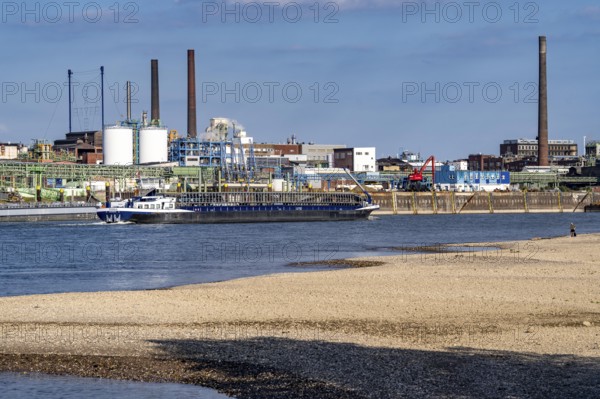 Low water of the Rhine near Leverkusen, Rhine bank, left bank of the Rhine, near Cologne-Merkenich, opposite Chempark Leverkusen, cargo ship on the Rhine, extremely low water level, no restrictions on inland navigation yet, North Rhine-Westphalia, Germany