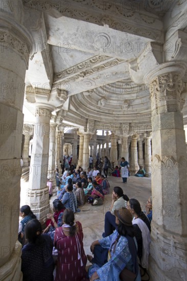 Indian woman praying between the white marble pillars in the Adinath temple in Ranakpur, Jain temple, Rajasthan, India