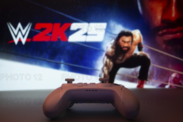 Dhaka, Bangladesh- 03 July 2025: A close-up of a white gamepad with The WWE 2K25 seen on screen in the background