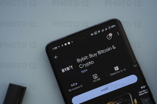 Dhaka, Bangladesh- 29 May 2025: On a blue surface, a smartphone displays the Bybit app within the Google Play Store