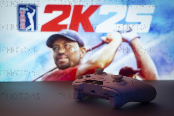 Dhaka, Bangladesh- 03 July 2025: A close-up of a white gamepad with The PGA TOUR 2K25 seen on screen in the background