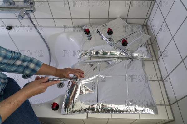 Filling a 10 litre water bag, for storing drinking water at home, as an emergency reserve in the event of a blackout or similar, lightweight, foldable, reusable bag made of multi-layer film, with dispensing device, for long-term storage of up to one year, recommended 3 litres of drinking water per person, for 10 days of storage