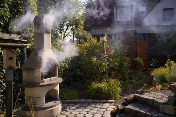 Smoke nuisance, nuisance to neighbours due to smoke, charcoal barbecue, barbecue in the garden, Stuttgart, Baden-Württemberg, Germany