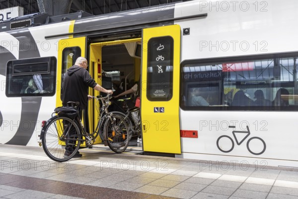 Platform with travellers and bicycles in front of the bicycle compartment. Central station with S-Bahn in Karlsruhe, Baden-Württemberg, Germany