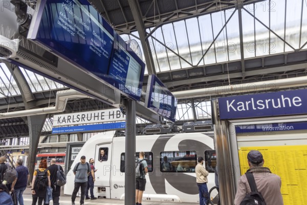 Platform with travellers at Karlsruhe main station with S-Bahn. Karlsruhe, Baden-Württemberg, Germany