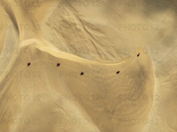 Quad bikes in the dunes of the Namib Desert in the vicinity of the coastal town of Swakopmund. Aerial view. Drone shot. Namibia