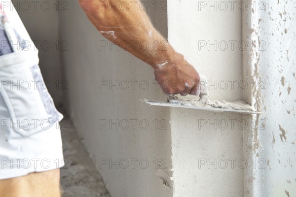 Plasterer smoothing and levelling interior walls