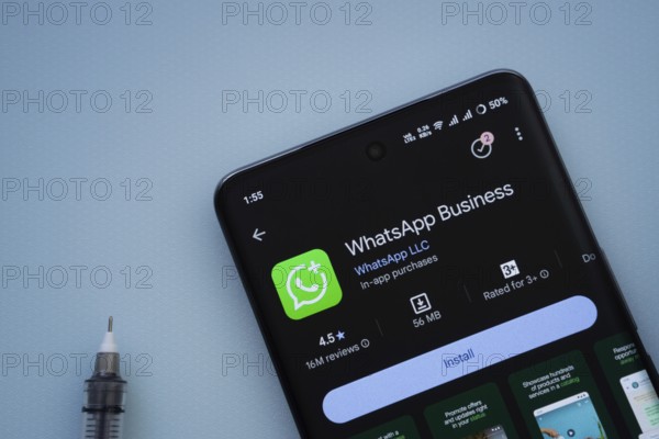Dhaka, Bangladesh- 29 May 2025: On a blue surface, a smartphone displays the WhatsApp Business app within the Google Play Store