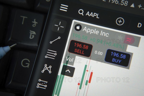 Apple Inc stock trading details on smartphone over a keyboard