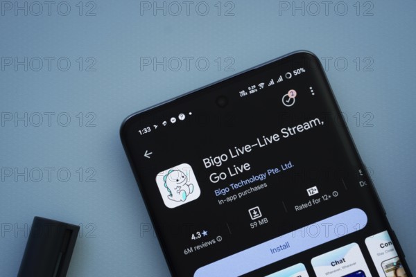 A smartphone displaying the Bigo Live app download page on a blue surface
