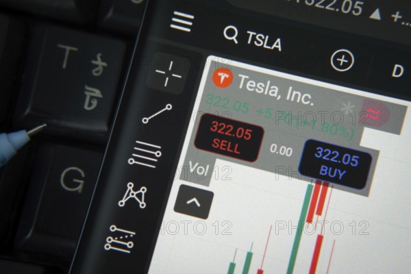 Dhaka, Bangladesh- 20 June 2025: Tesla stock trading details on smartphone over a keyboard