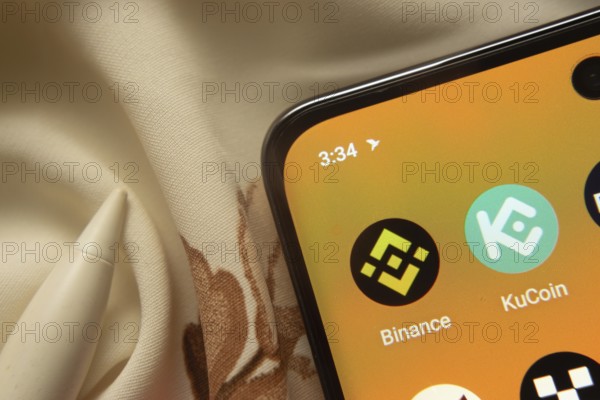 Dhaka, Bangladesh- 07 May 2025: Binance and KuCoin app icon is seen on smartphone