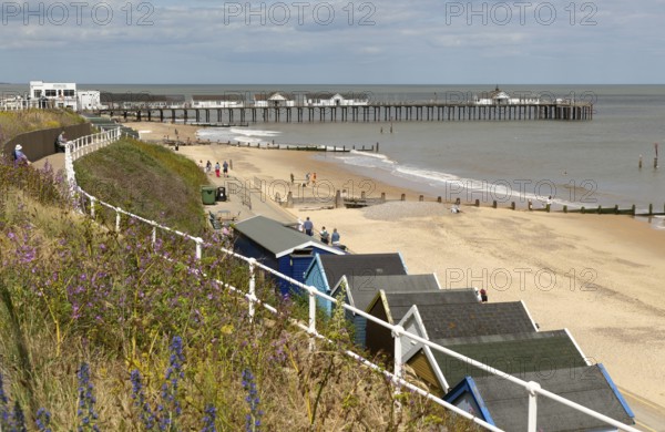 View over beach huts to sandy beach and pier, Southwold, Suffolk, England, UK